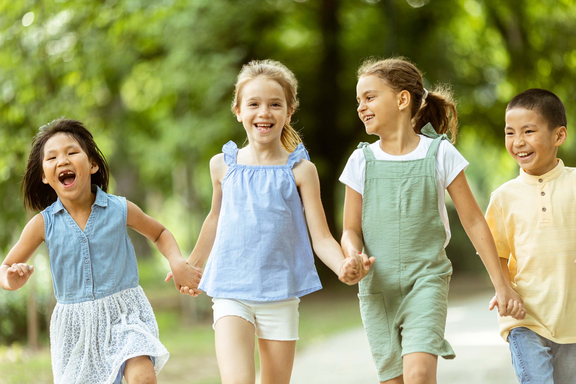 Group of asian and caucasian kids having fun in the park