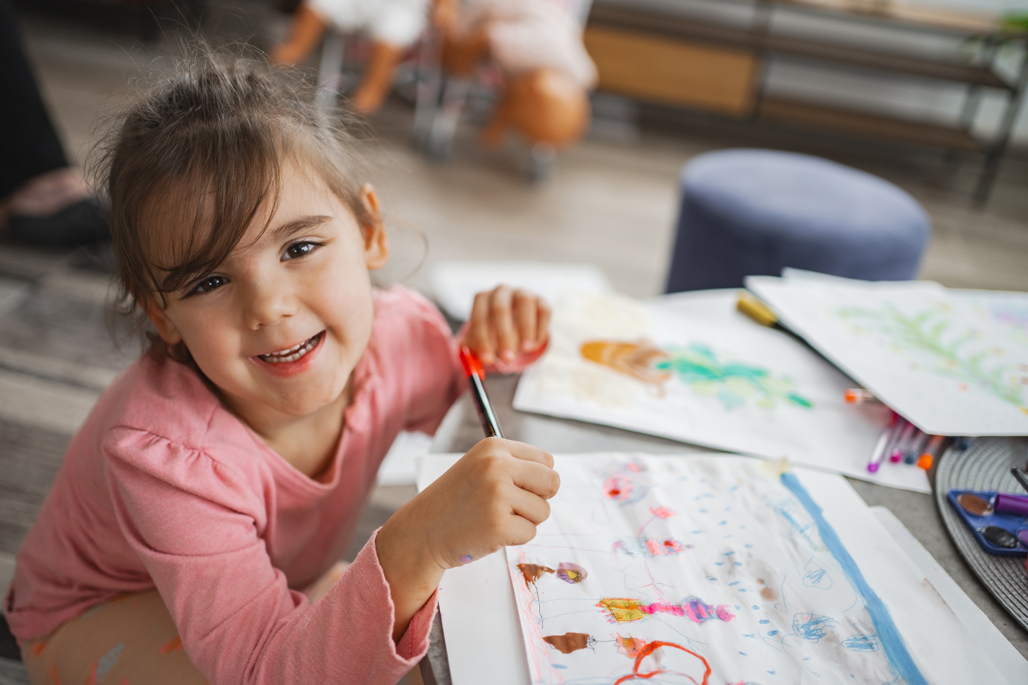Little artist joyfully creating colorful drawings at home