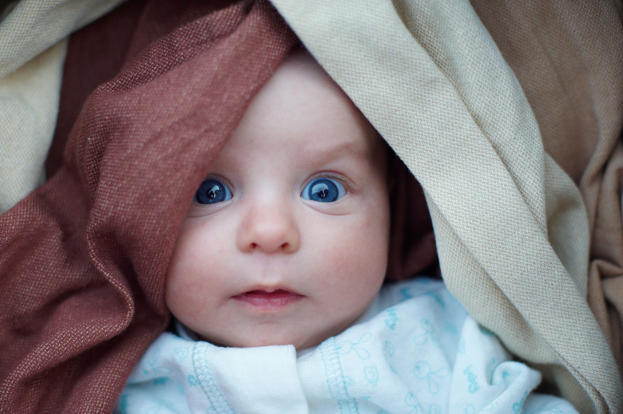 Adorable baby boy in bedroom. Newborn infant child relaxing in bed